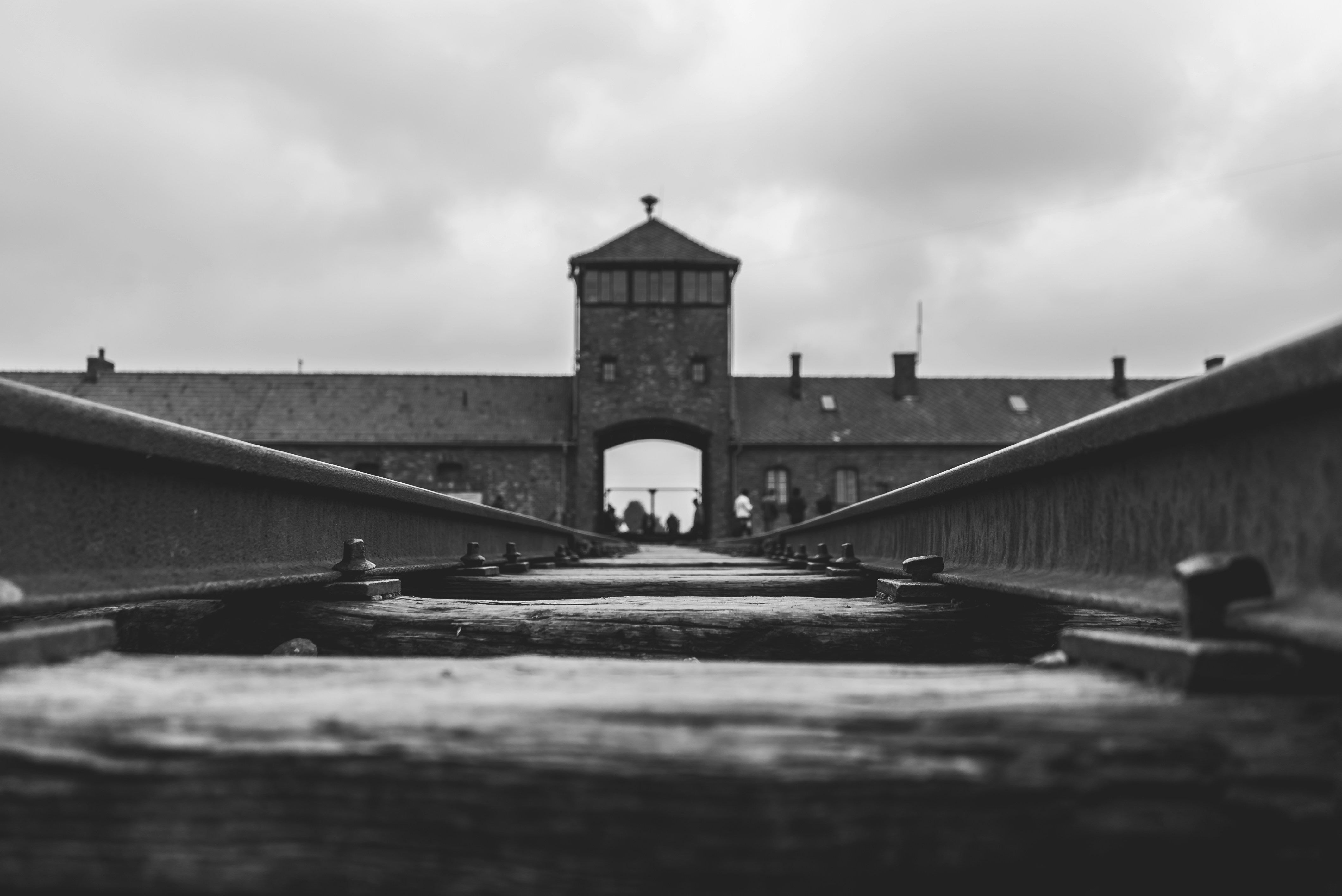 Graustufenfoto der Bahngleisen des ehemaligen Konzentrationslagers Auschwitz